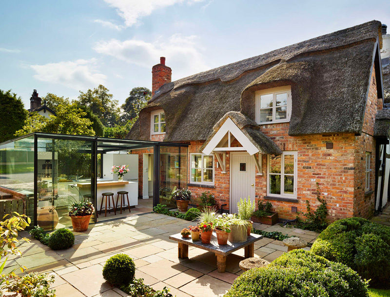 This thatched cottage got a glass box extension for the kitchen 2